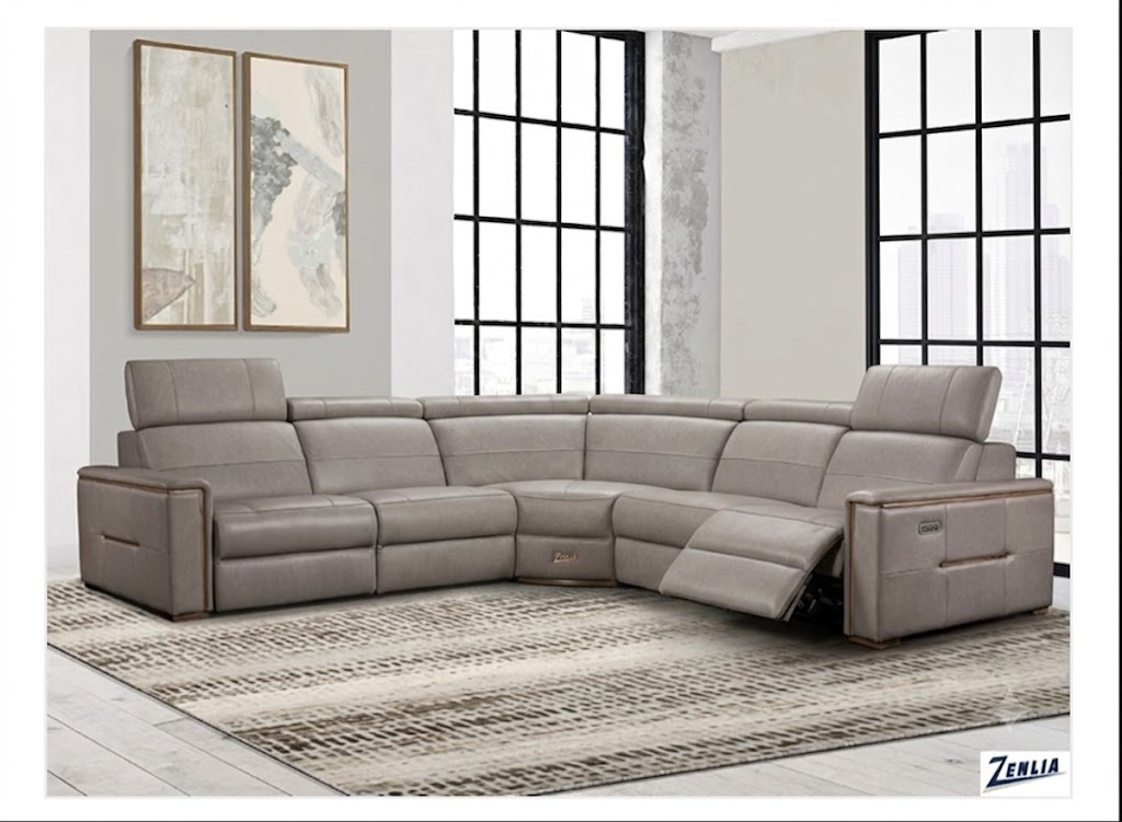 Gray leather reclining sectional placed in a bright room with two large windows in the background.