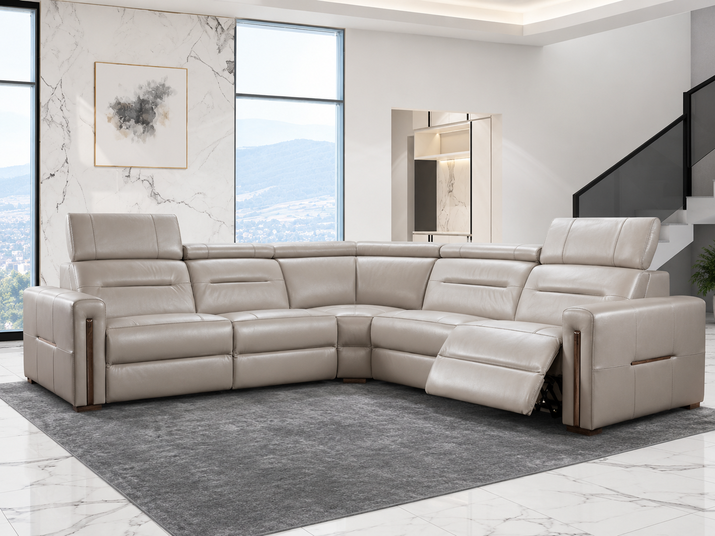 A modern living room features a set of sleek, beige leather recliners on a plush gray rug. The left recliner is upright, while the right one is partially reclined. Large windows and marble accents create a bright, elegant atmosphere.